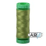 Spool of green thread with 'Aurifil' branding on a white background