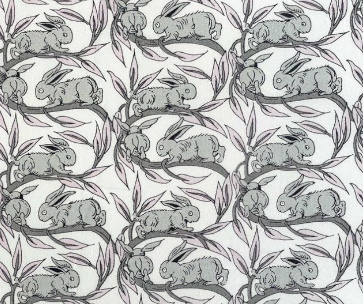 Pattern of gray rabbits on branches with leaves on a white background