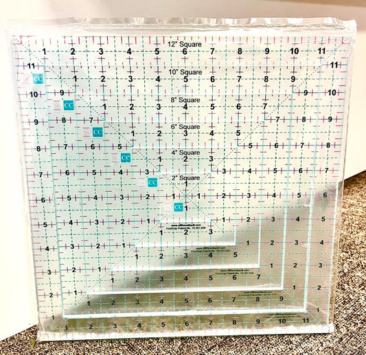 Set of clear acrylic rulers with grid lines and measurements on a textured surface