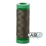 Spool of green thread with a visible brand label on a white background