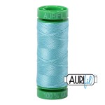 Spool of light blue thread with green end cap on a white background