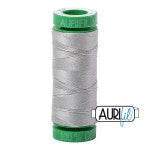 Spool of gray thread with green label on a white background