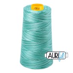 Turquoise spool of thread with a yellow label on a white background