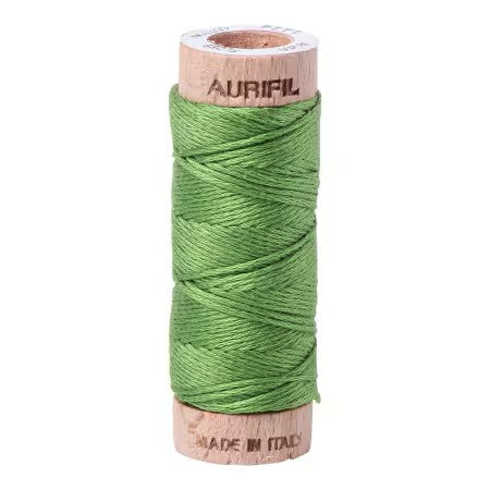 Spool of green thread on a wooden spool with 'Aurifil' branding on a white background
