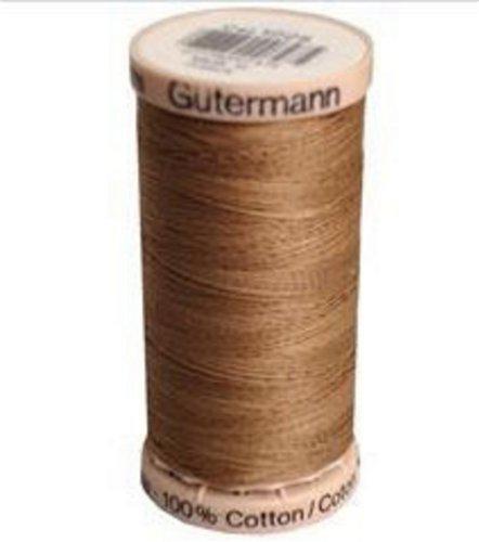Spool of Gutermann brown thread on a white background