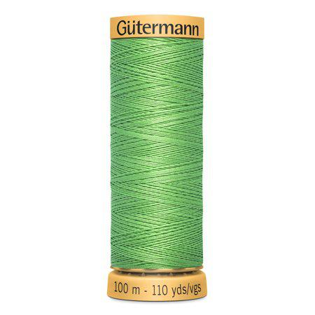 Green spool of Gutermann thread on a white background