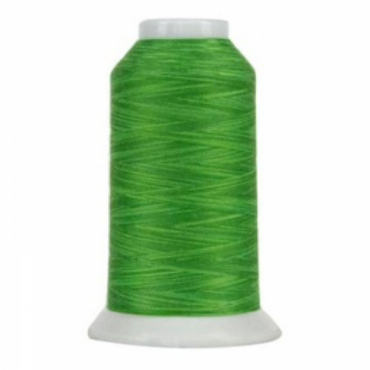 Spool of green thread on a white background