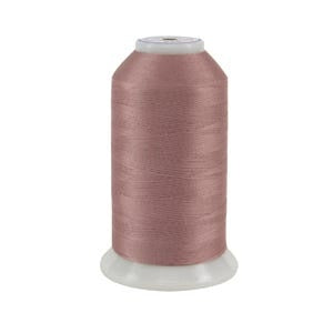 Spool of pink thread on a white background
