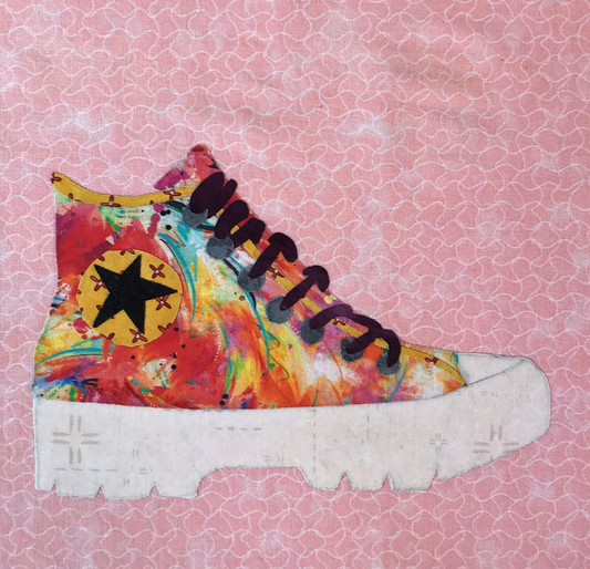 Colorful high-top sneaker with a star design on a pink patterned background