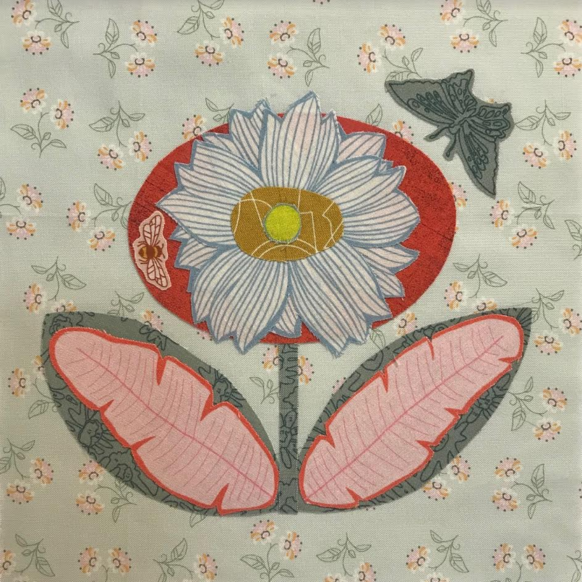 Decorative fabric pattern with a large flower and butterflies on a light green background.