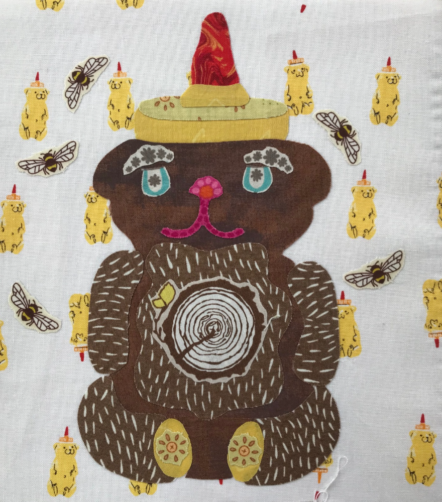 Fabric with a bear design and small bear and bee patterns on a white background