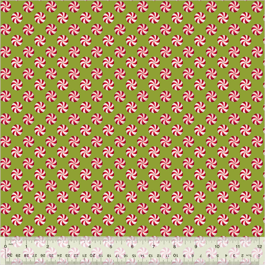 Pattern of red and white peppermint swirls on a green background with a ruler at the bottom.