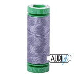 Spool of thread with a green top, labeled 'AURØ', on a white background