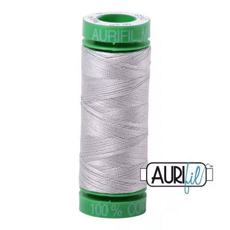 Spool of Aurifil thread with green label on a white background