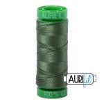 Spool of green thread with a brand logo on a white background