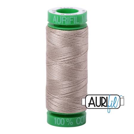 Spool of Aurifil thread with green label on a white background