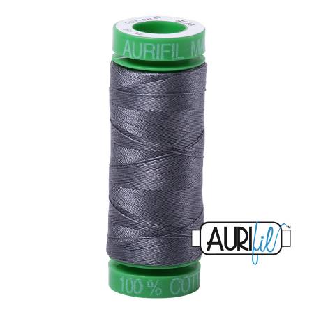 Spool of Aurifil thread with green label on a white background