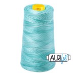 Spool of teal thread with a yellow label on a white background