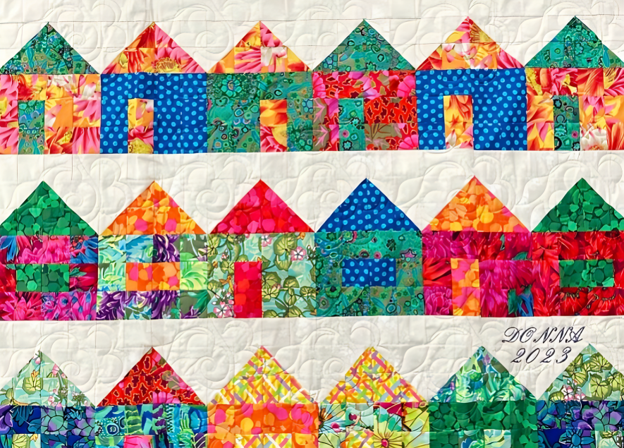 Charming Village Quilt made using the Charming Village Quilt Pattern by instructor Donna Galvan, featuring colorful patchwork houses and quilted fabric collage details.