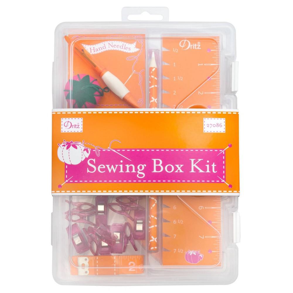 Sewing box kit with various sewing tools in a clear plastic case on an orange background