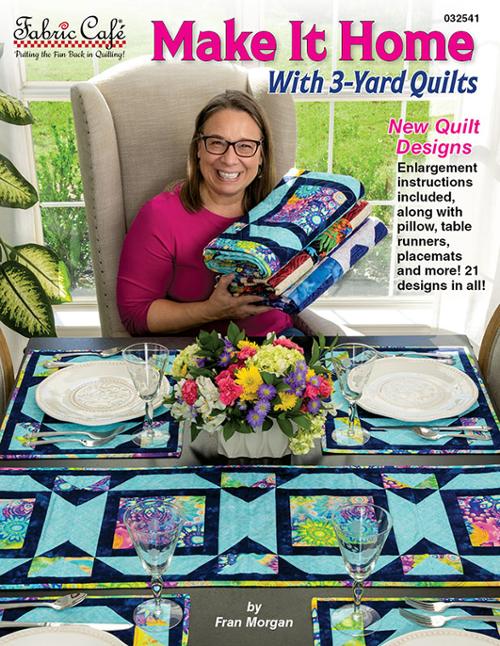 Woman holding a quilt with a table setting and floral centerpiece, featuring 'Make It Home with 3-Yard Quilts' book.