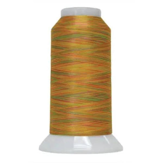 Spool of green and orange thread on a white background
