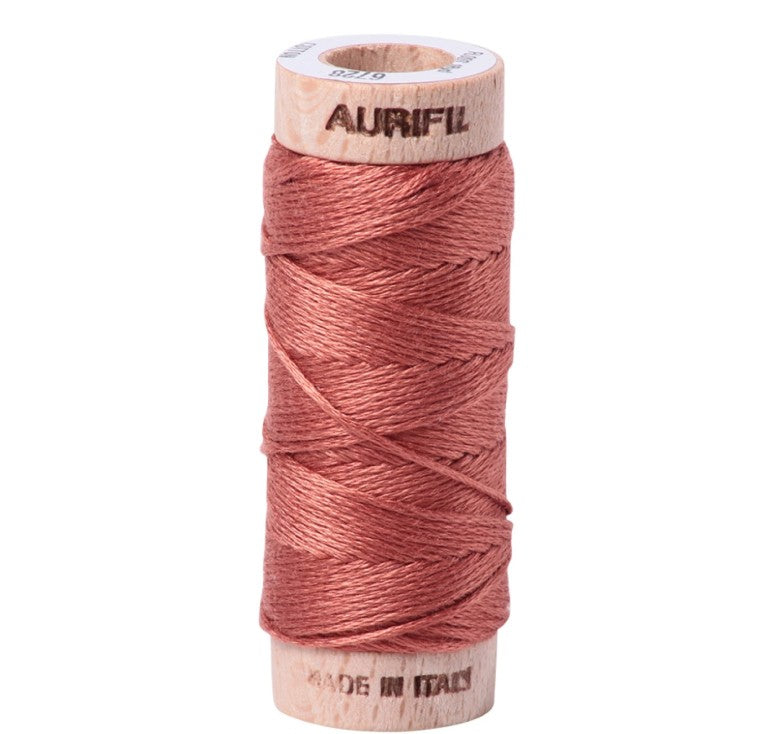 Spool of Aurifil thread on a white background