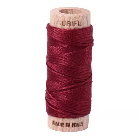 Spool of red thread on a white background with 'Aurifil' branding.