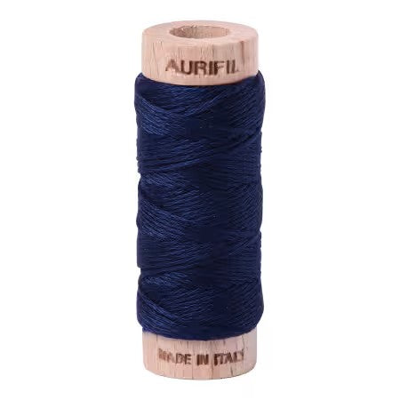 Spool of dark blue thread with wooden spool and label on a white background