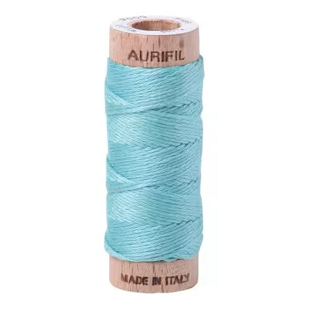 Spool of Aurifil thread on a white background