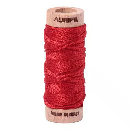 Red spool of Aurifil thread on a white background