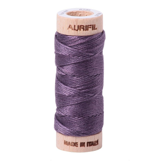 Spool of purple thread with wooden spool and Aurifil branding on a white background