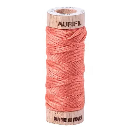 Spool of Aurifil thread on a white background