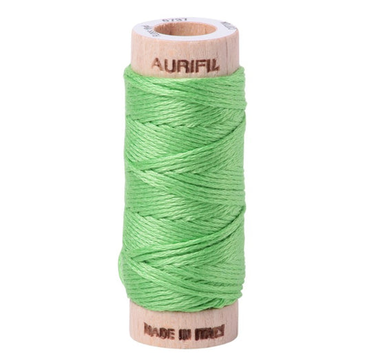 Spool of green thread on a wooden spool with 'Aurifil' branding on a white background