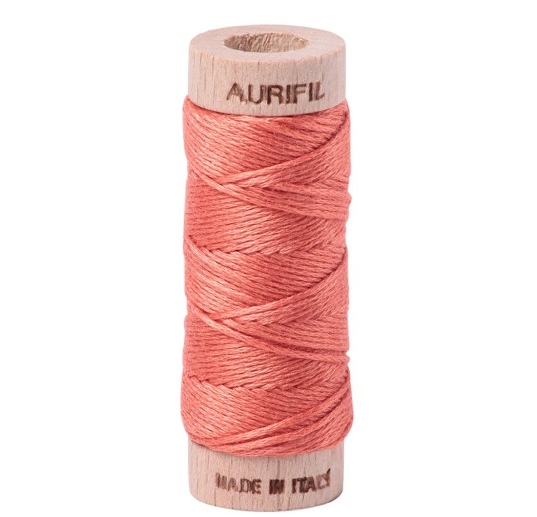 Spool of pink thread on a white background with 'Aurifil' branding.