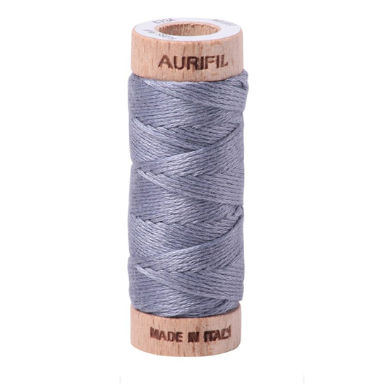 Spool of Aurifil thread on a white background