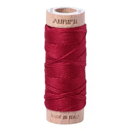 Red spool of Aurifil thread on a white background