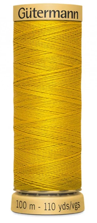 Spool of yellow Gutermann thread on a white background