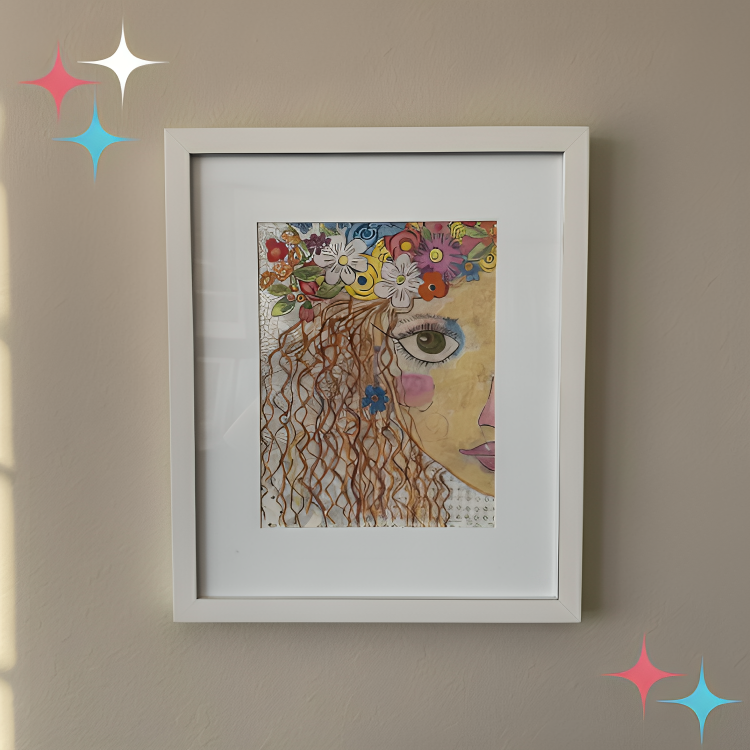 Framed artwork of a woman's face with flowers on her head against a beige wall.