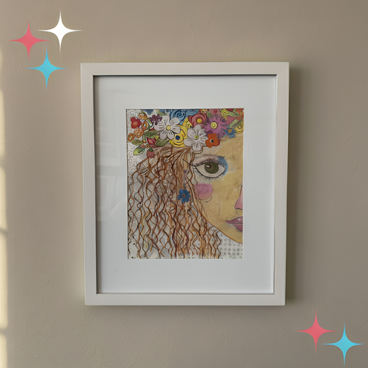 Framed artwork of a woman's face with flowers on her head against a beige wall.
