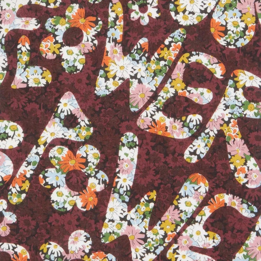 Textured fabric with floral lettering on a dark red background
