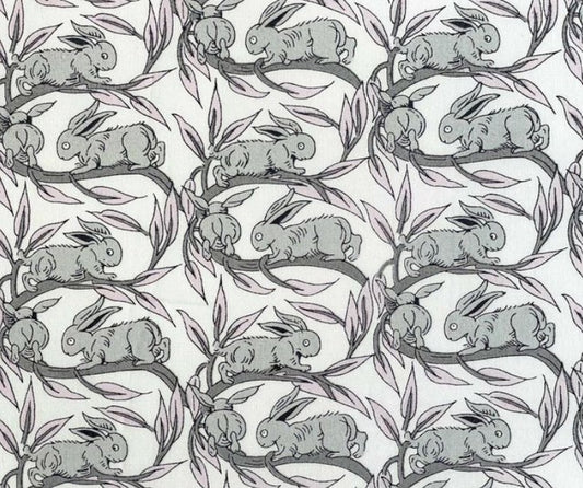 Pattern of gray rabbits on branches with leaves on a white background