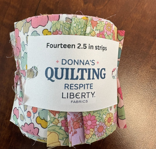 Pack of quilt fabric strips with a label on a wooden surface