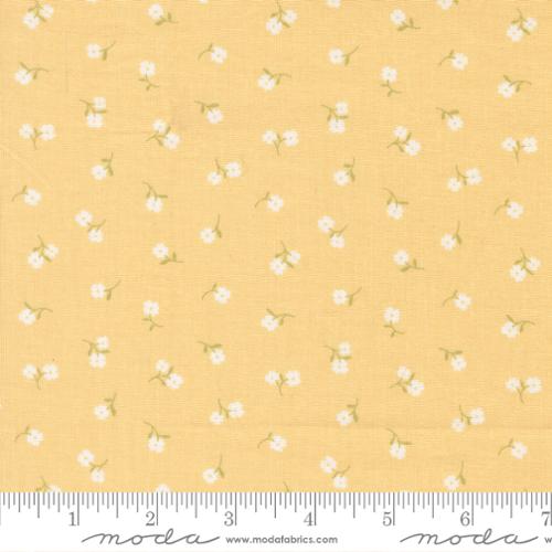 Fabric with small white floral pattern on a yellow background, featuring Moda label.