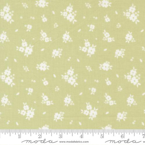 Fabric pattern with small white flowers on a light green background, featuring Moda label.