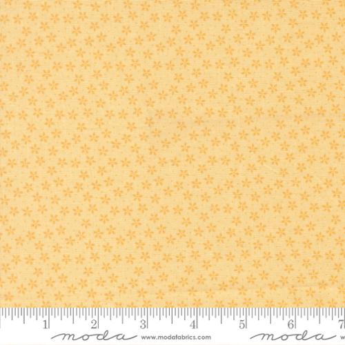 Fabric pattern with small star shapes on a yellow background, featuring Moda label.