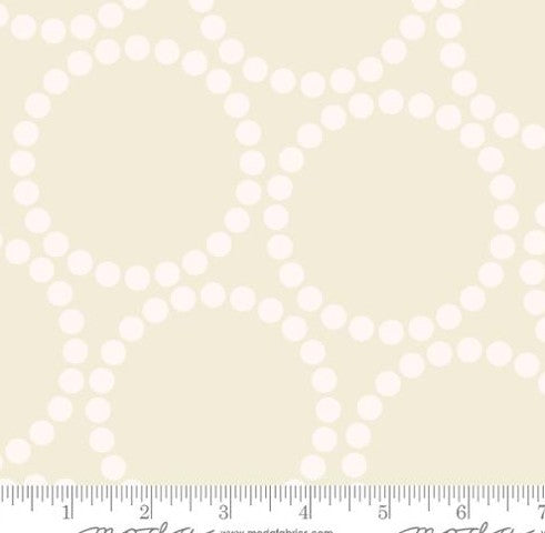 Pattern of white circles on a beige background with a ruler at the bottom.