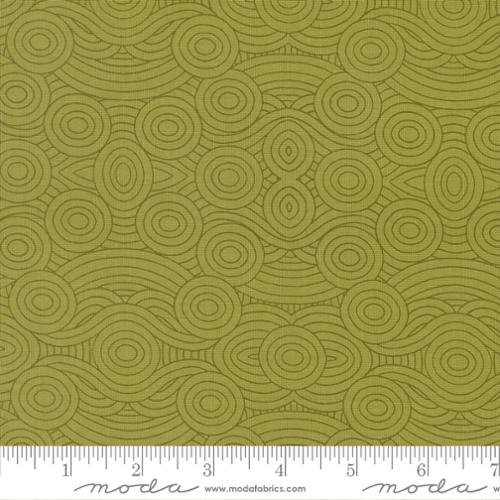 Green fabric with circular pattern and ruler for scale