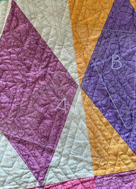 Quilt with purple, yellow, and white triangles featuring floral patterns.