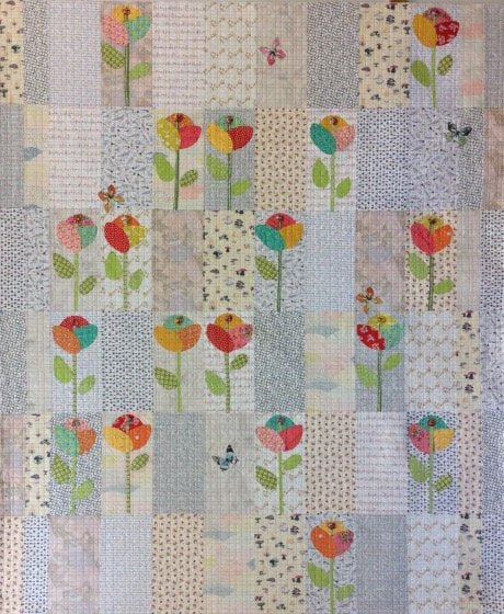 Patchwork quilt with floral patterns and small animals on a textured background